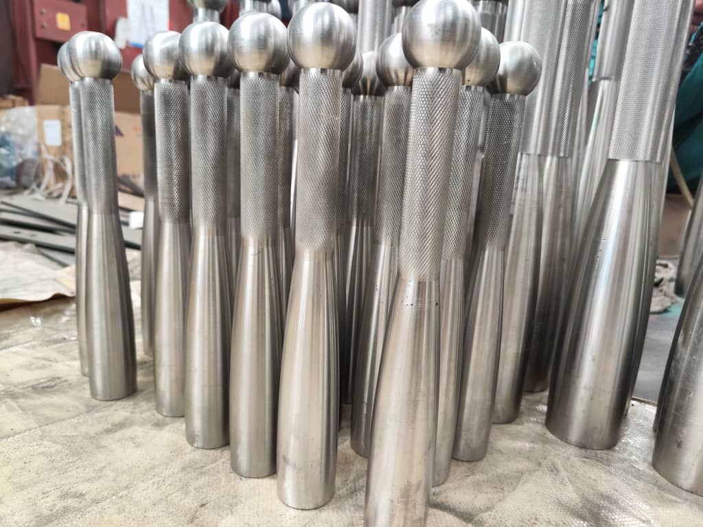 Close-up of rounded pommels and knurled handles on stainless steel club examples